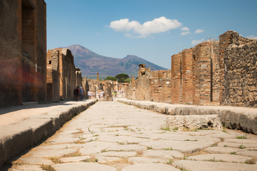 Stone-paved street in Pompeii leading toward Mount Vesuvius